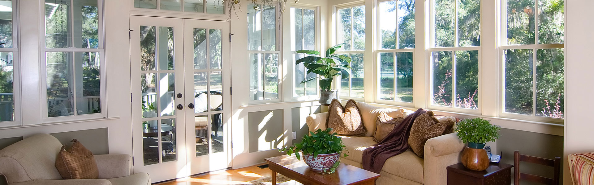 a series of hung windows in a sunroom with patio doors